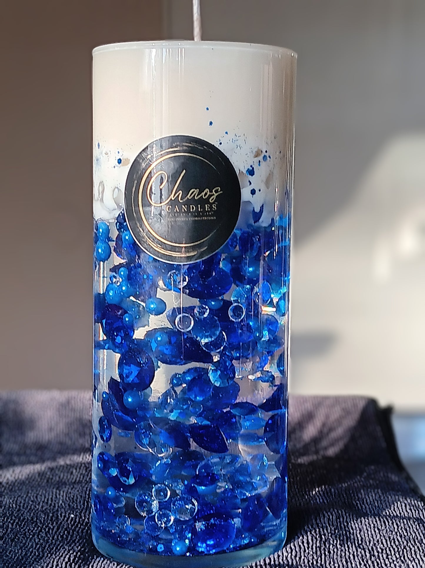 Blue luxury pillar soy candle sealed in a glass cylinder with beads — handmade by Chaos Candles.