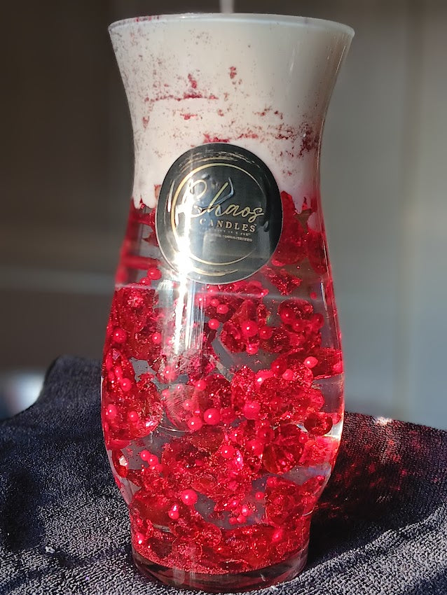 Soy wax curved vase candle with suspended scarlet beads and Chaos Candles label, photographed in natural light.