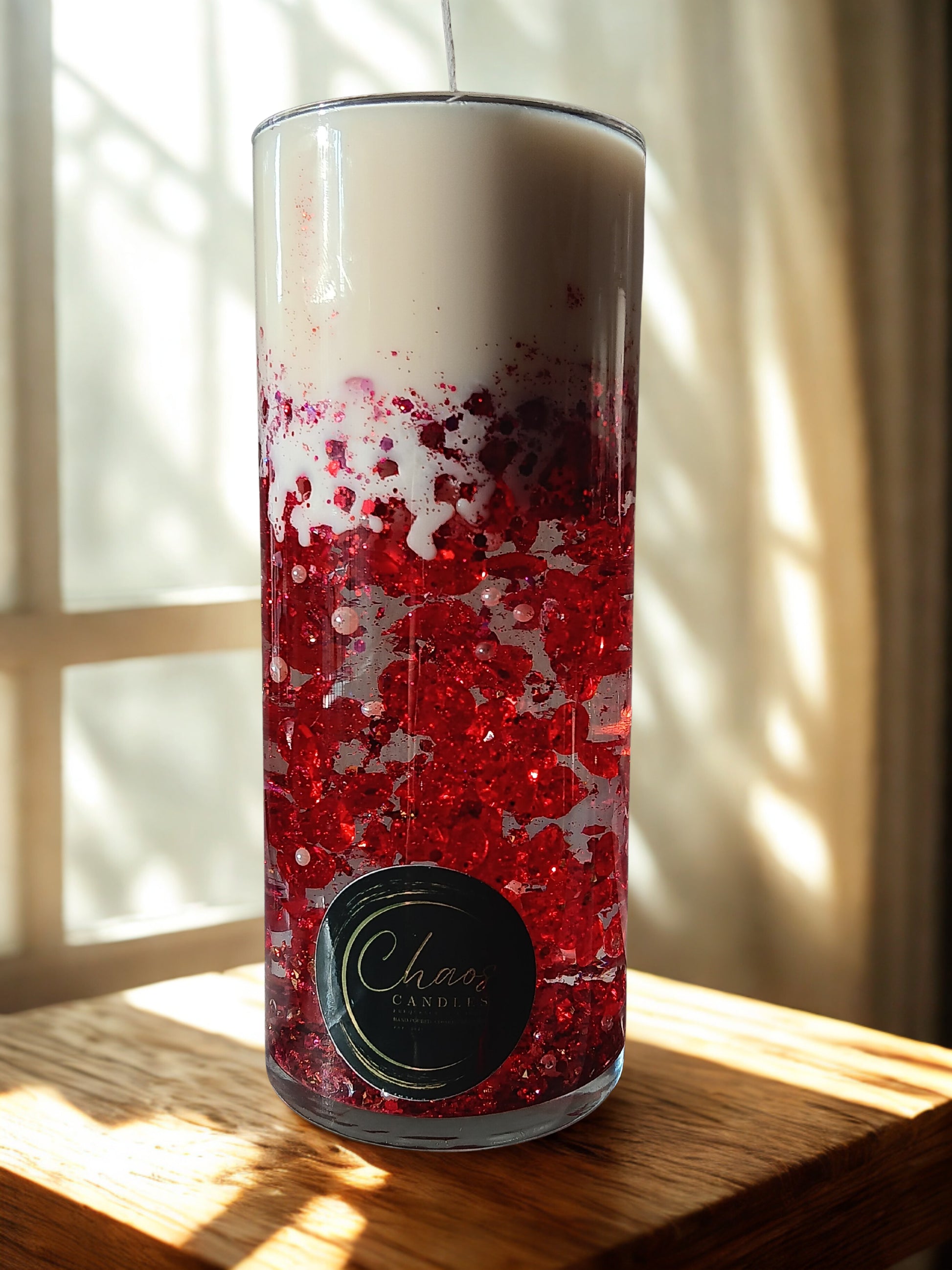 Luxury red pillar vase candle with soy wax top and suspended ruby accents, handcrafted by Chaos Candles.